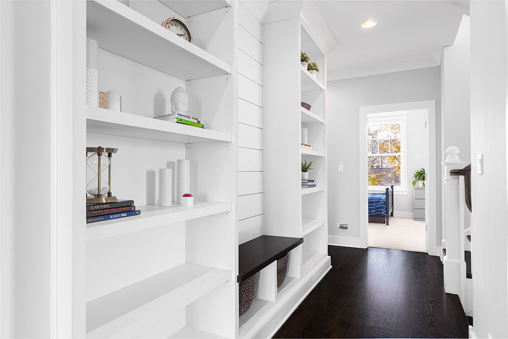 Hallway with built-in shelving for decor items and stylish hardwood floor flooring